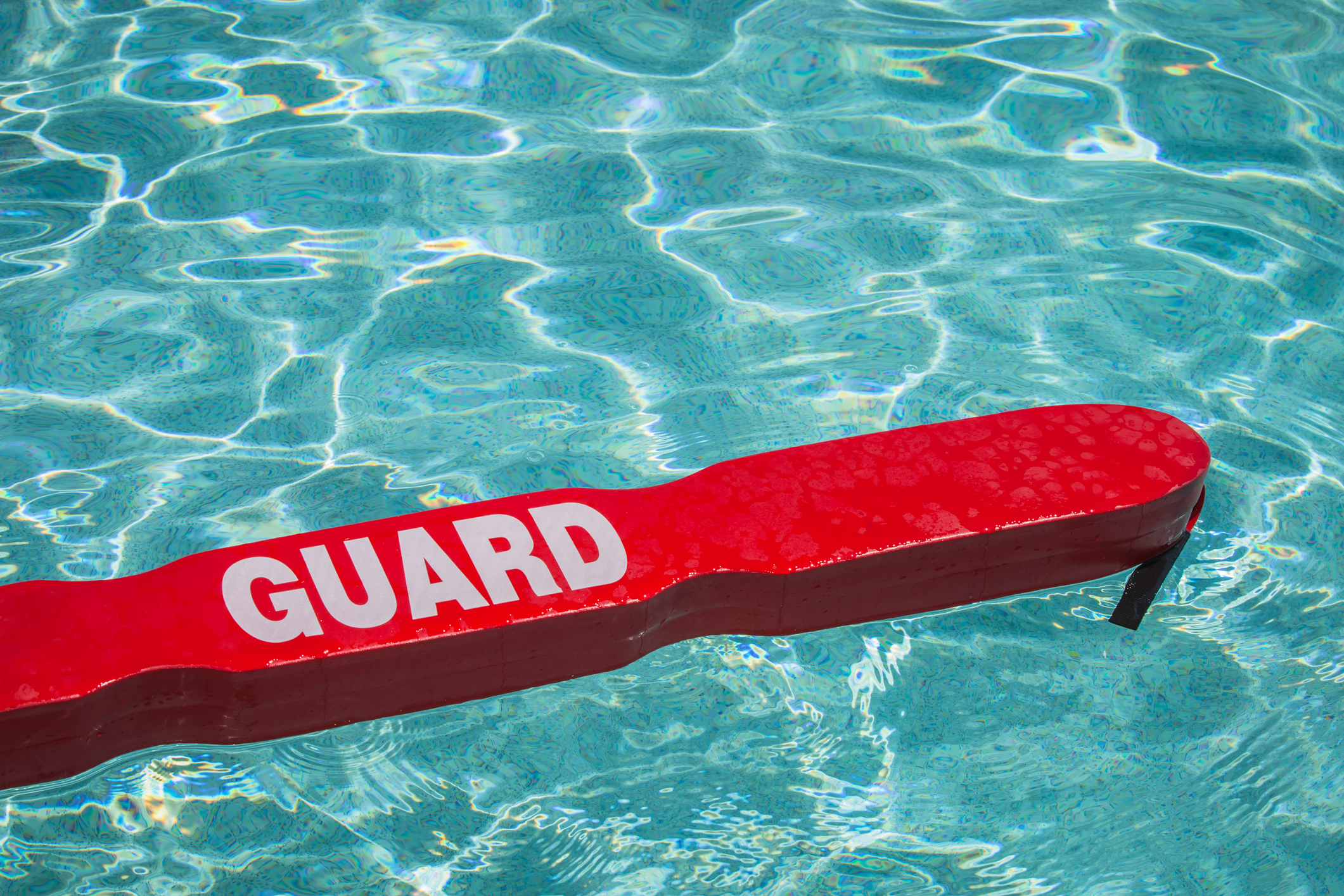 life guard's red rescue tube floating in a pool.