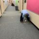 Mitarbeiter Person markiert 6-Fuß-Entfernungen auf dem Flurboden