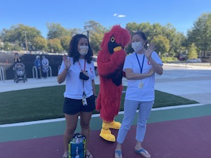 two teachers next to the cardinal mascot