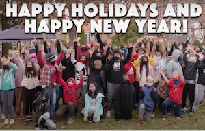 Grafik, die frohe Feiertage und ein frohes neues Jahr mit Studenten im Hintergrund sagt