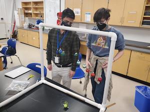 الطالب والمعلم ينظران إلى مشروع علمي