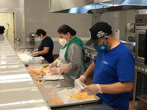 Foto von Cafeteria-Mitarbeitern, die Essen zubereiten
