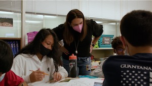 سوشل اسٹڈیز کلاس روم کی ویڈیو، اسائنمنٹ پر طلباء کے ساتھ استاد کام کر رہے ہیں۔