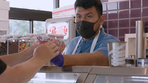顧客にアイスクリームを提供する人