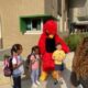 mascotte de l'école posant avec les élèves le premier jour