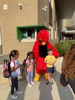 school mascot posing with students on first day