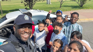 police officer posing for photo with students