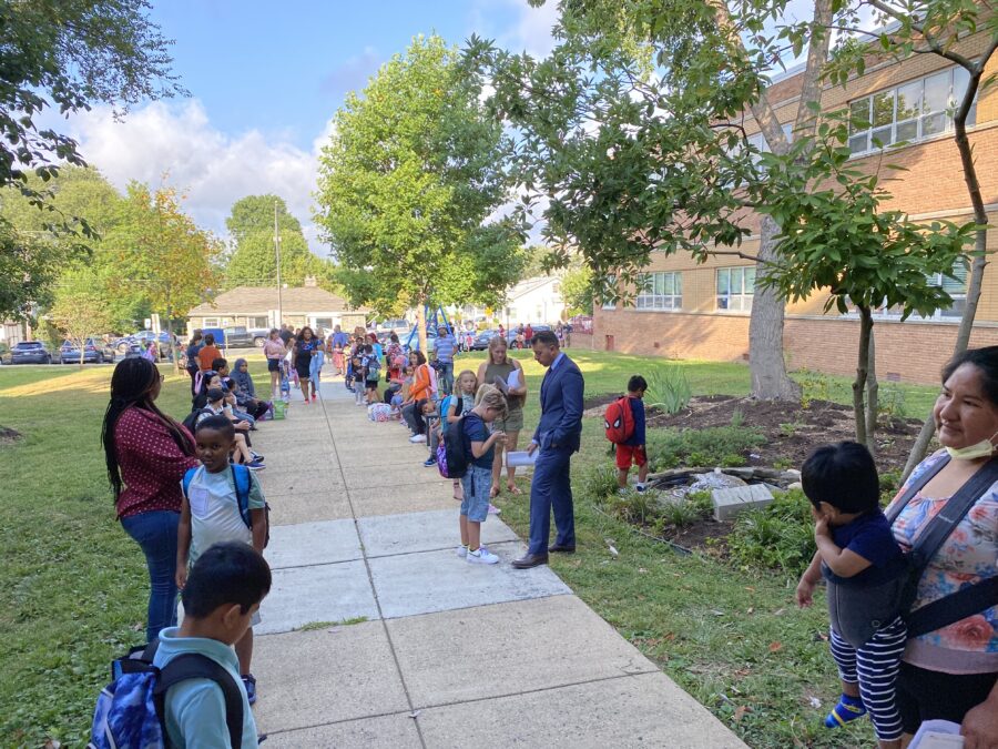 les élèves et les familles se sont réunis à l'extérieur le premier jour d'école