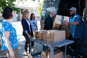 bénévoles déchargeant des cartons d'une camionnette Amazon