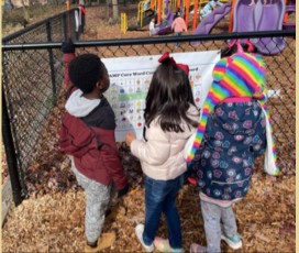 image of children looking at Core Board on playground
