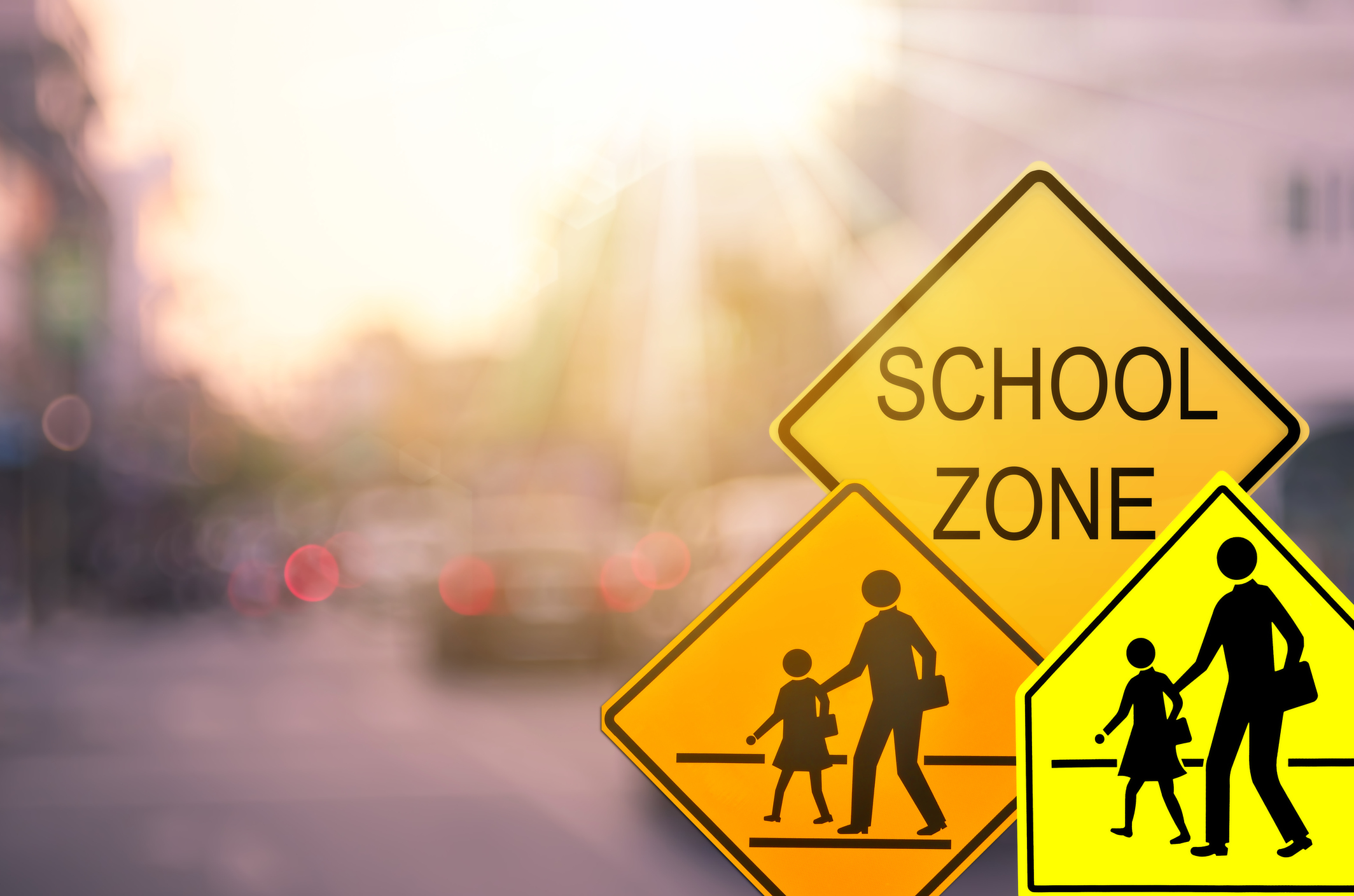 School zone warning sign on blurry road