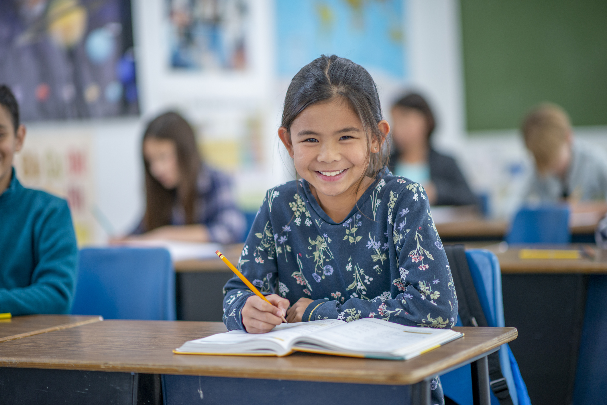 student at desk smiling