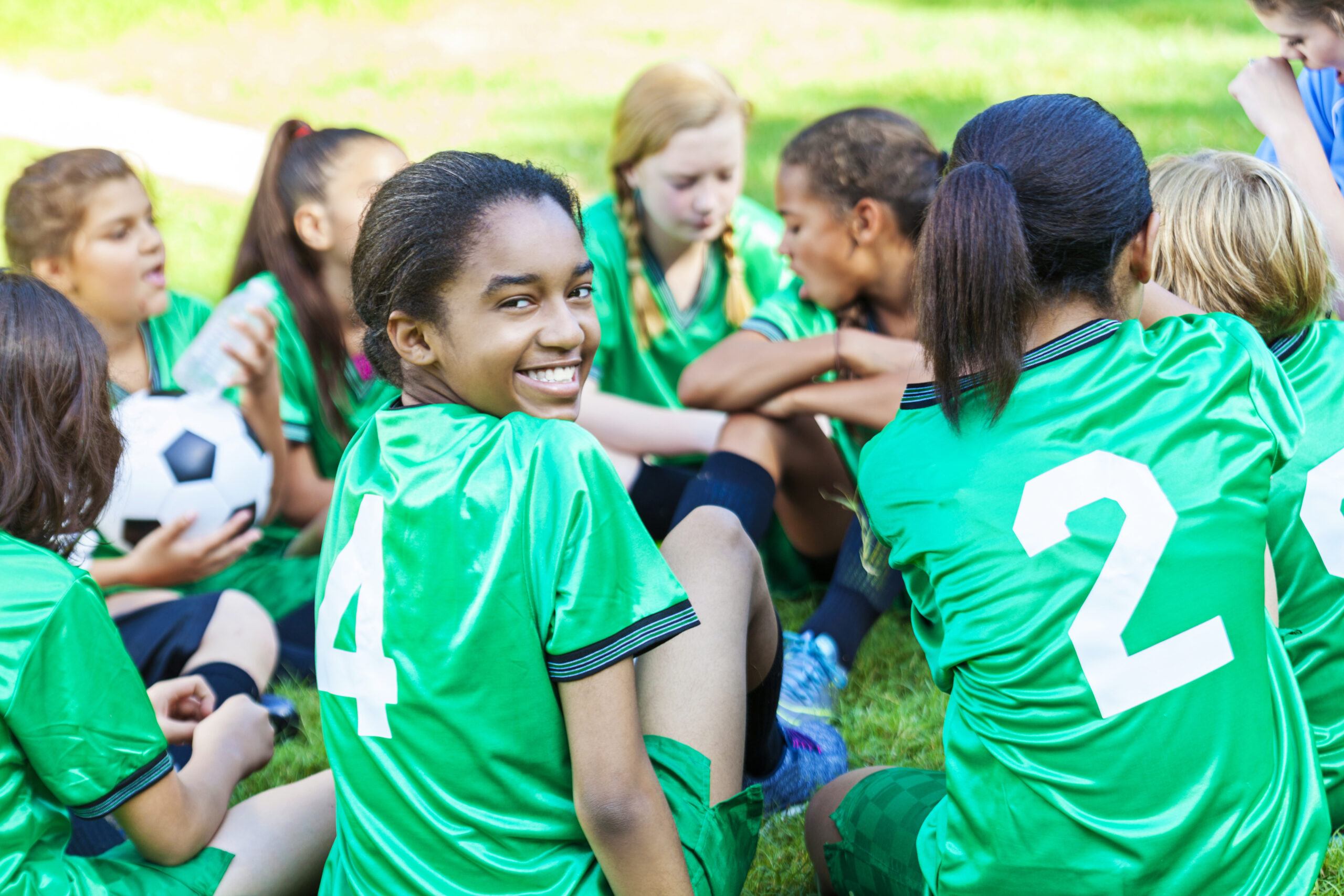 African American girl smiling with her soccer team