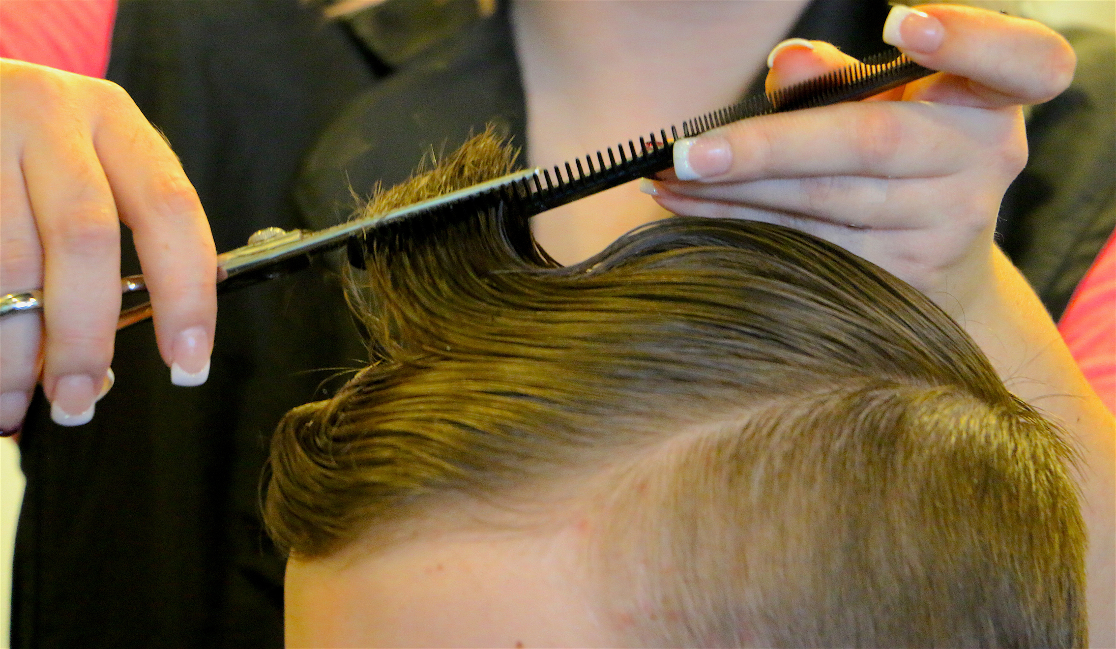 close up of cosmetologist cutting hair