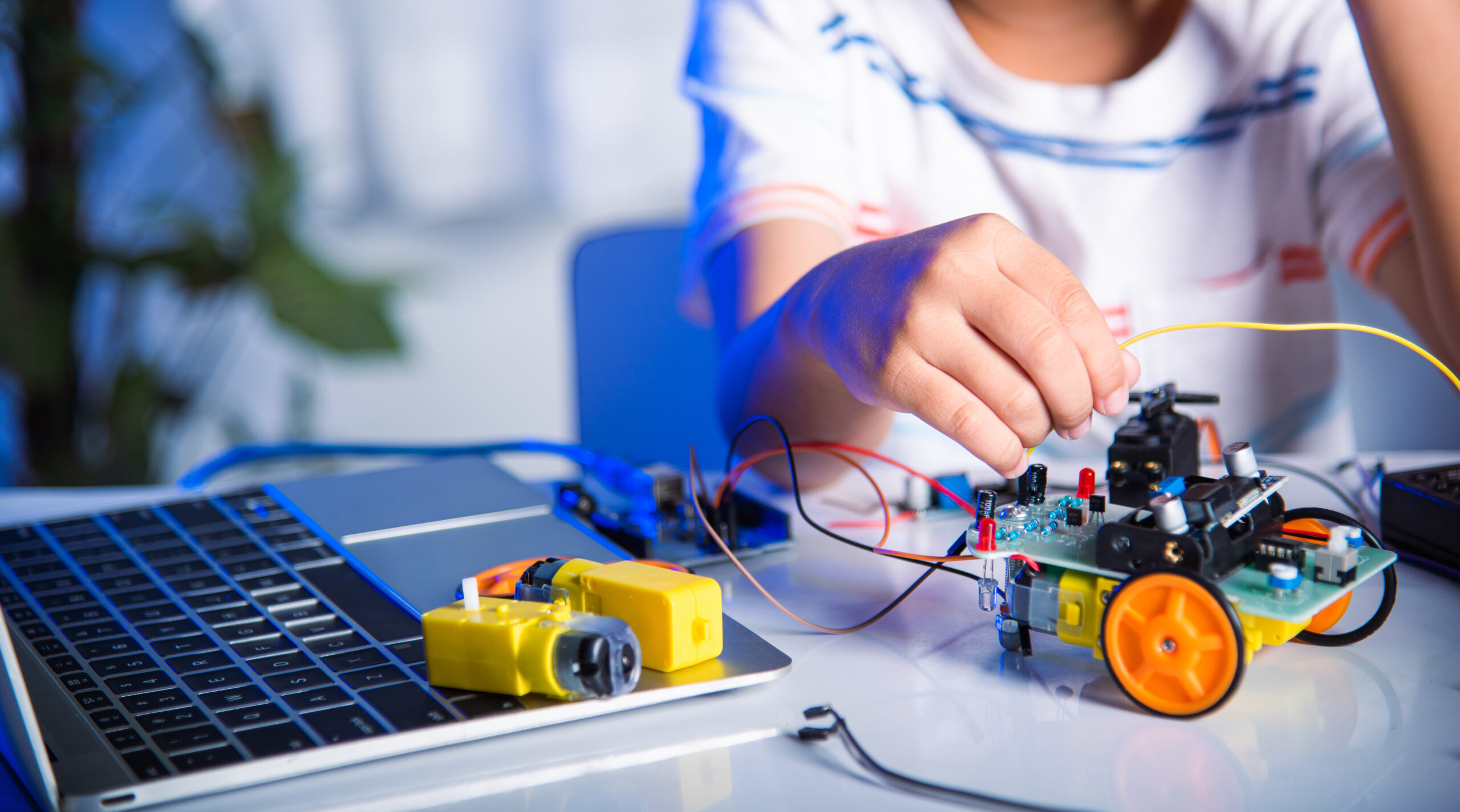 child programming a robotic car model