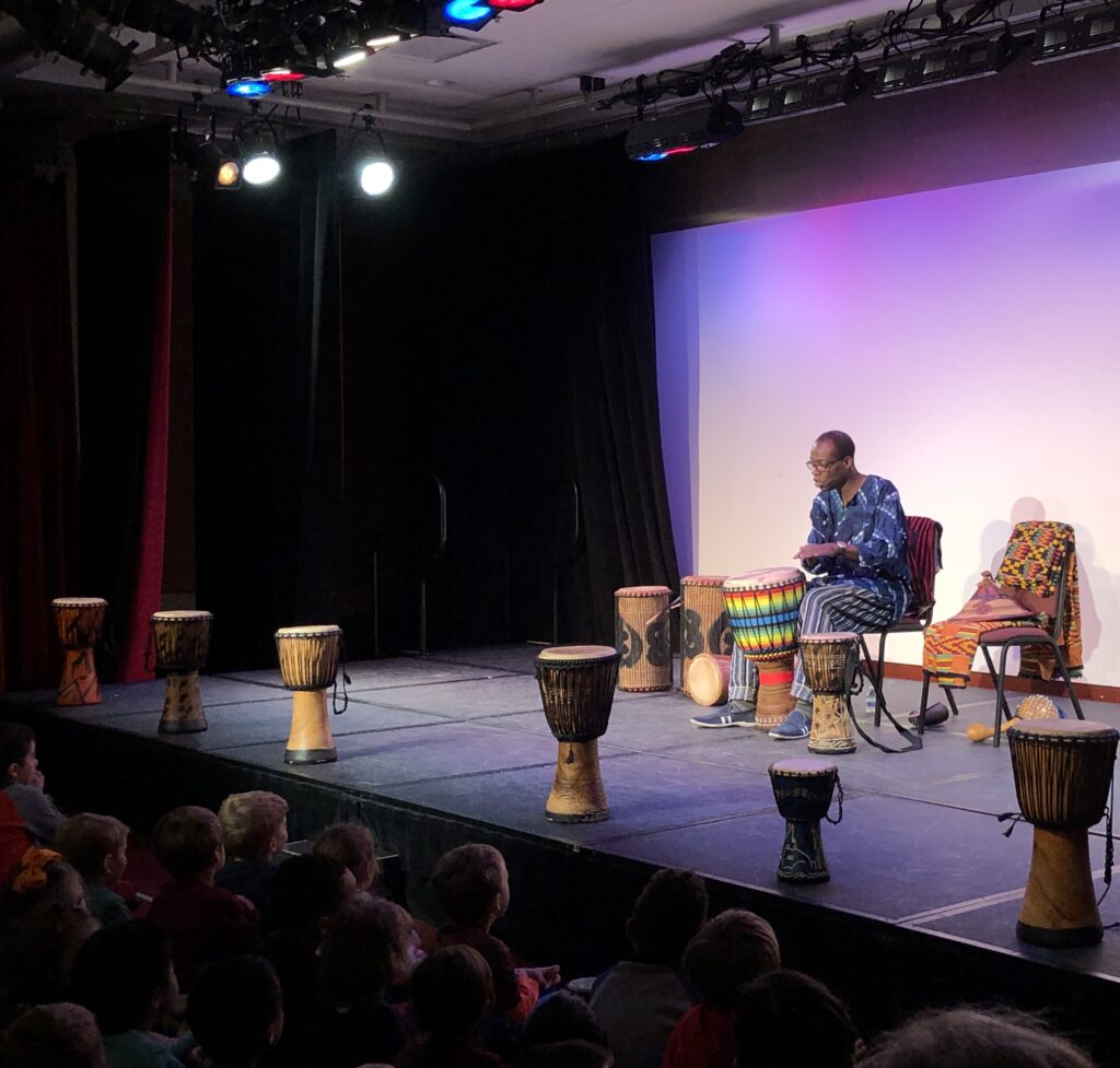 Kofi Dennis performing for students