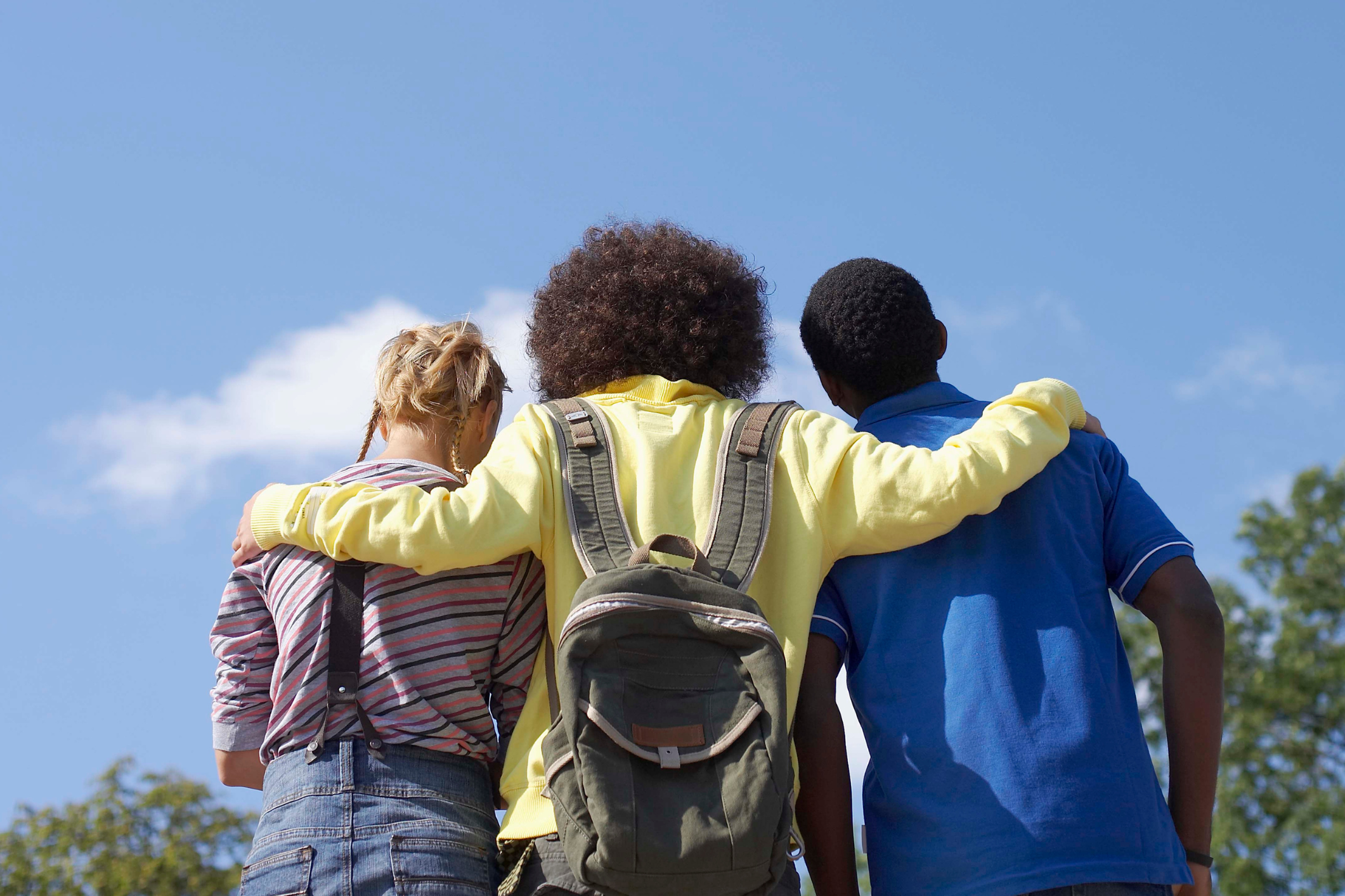 Three students from the back hugging