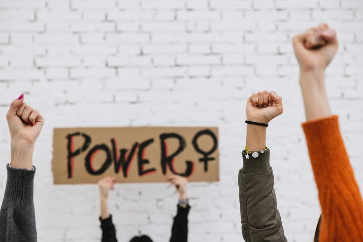 Activists protesting for equal women's rights holding messages