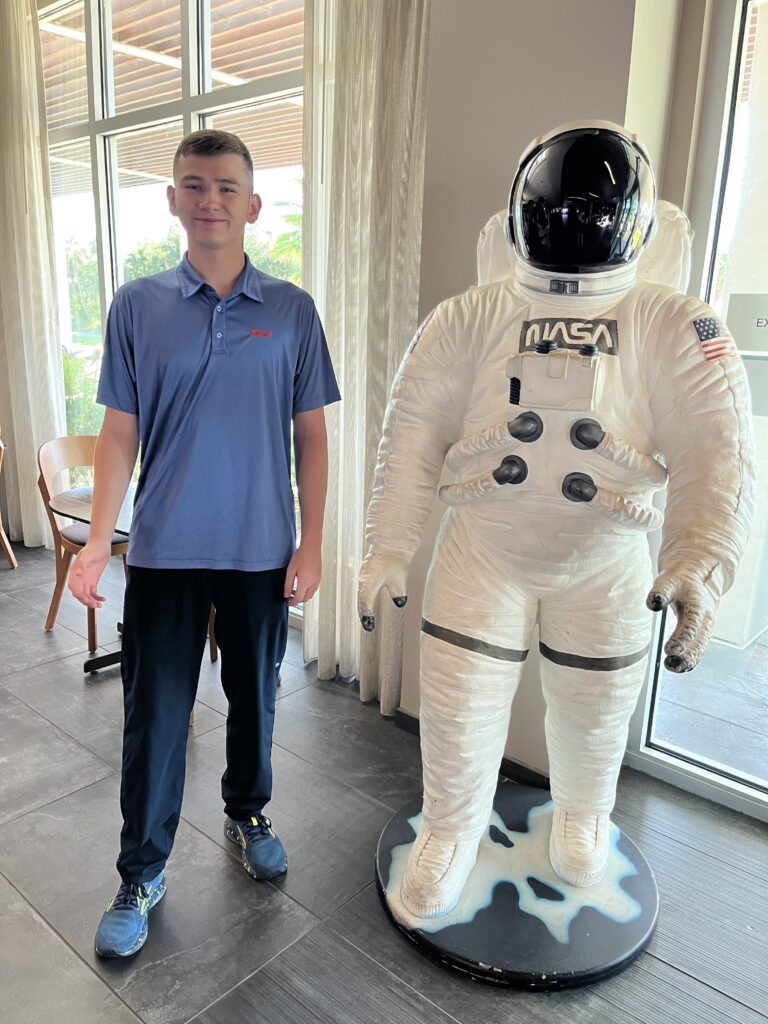 student standing next to spacesuit