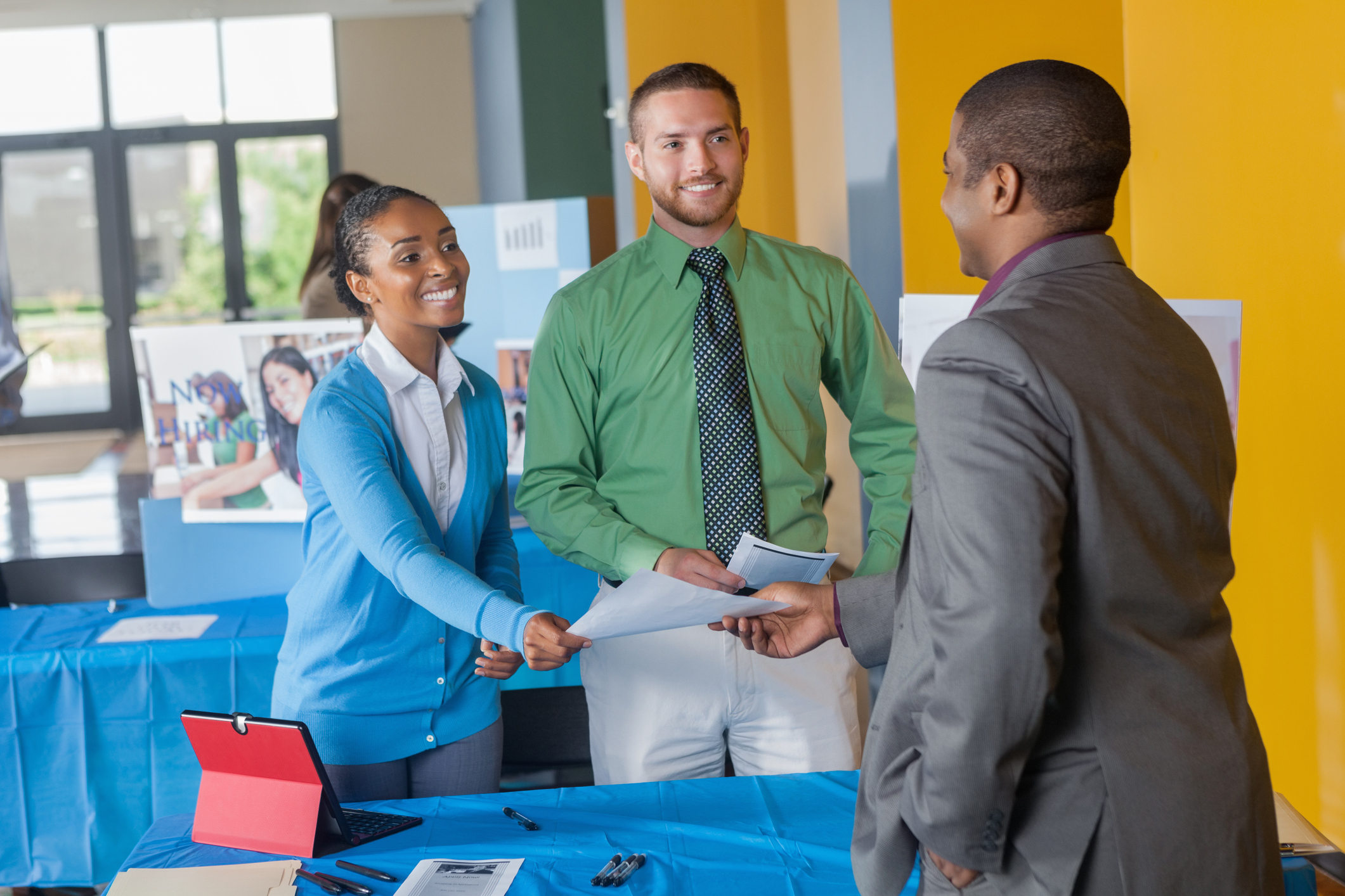 adults shaking hands at a job fair