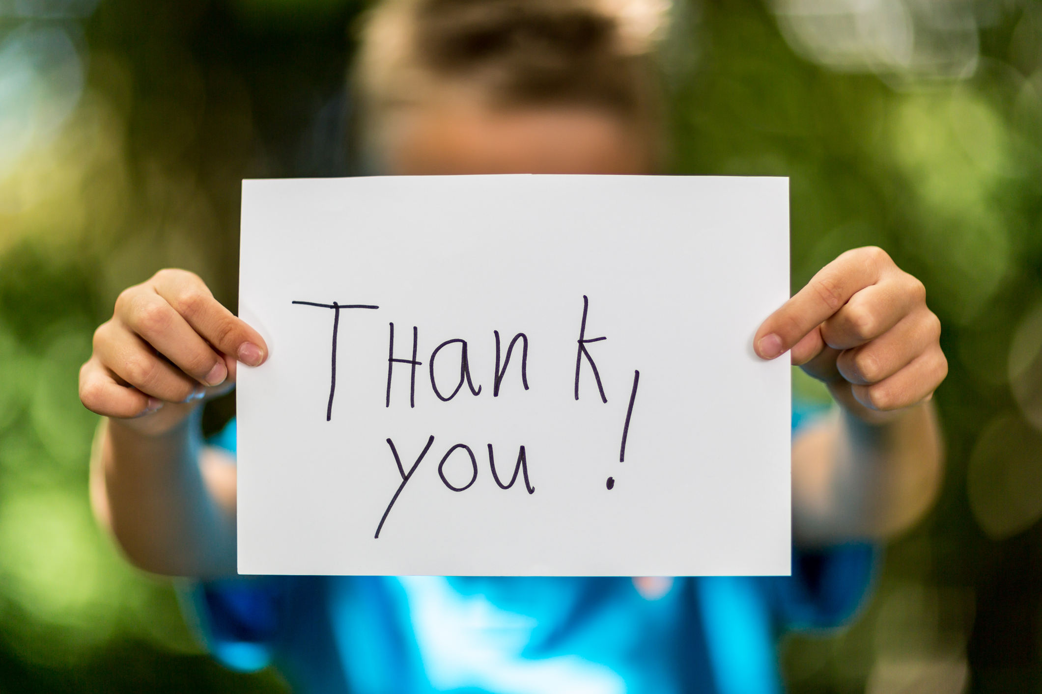 boy holding a piece of paper with the words Thank You