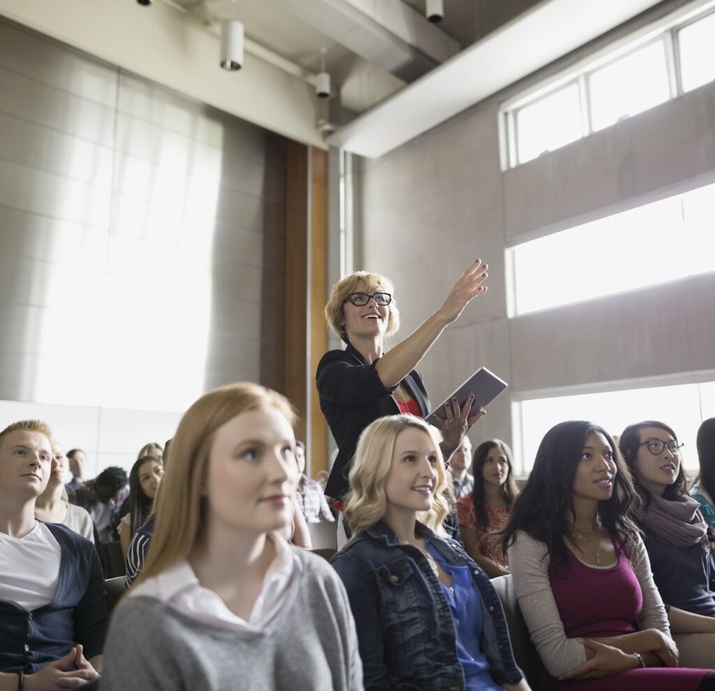 Person in an audience standing to ask a question 