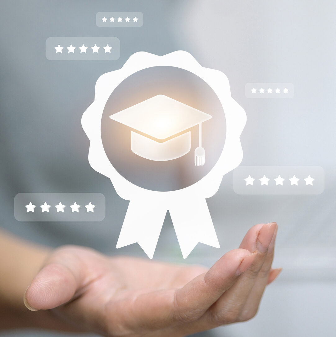 Hand holding graduation cap badge with 5-star rating icons